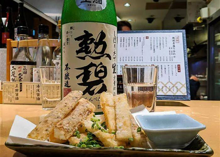 A bottle of sake and izakaya food at the Nagoya nightlife tour.